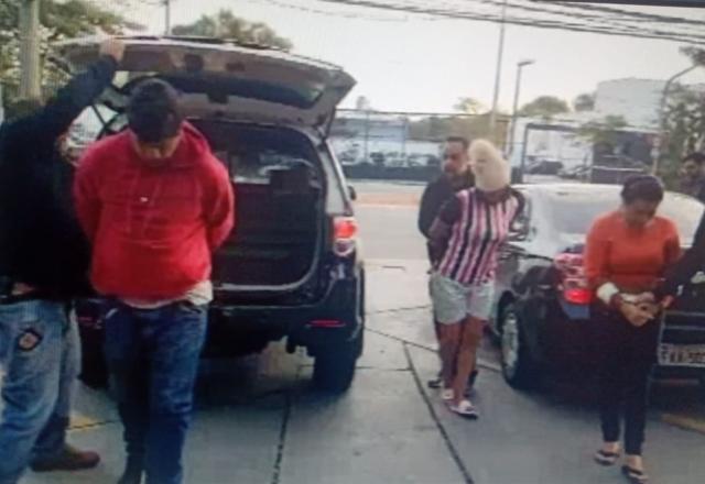Um homem e duas mulheres sendo presos