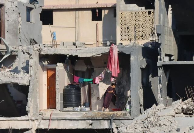 Uma menina palestina limpa o chão de uma casa gravemente danificada em Abasan Al Kabira, área de Khan Younis | OCHA/Themba Linden