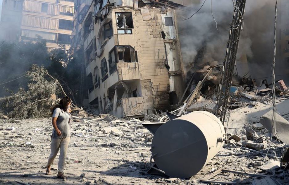 Uma mulher passa por um prédio destruído nos subúrbios ao sul de Beirute, a capital libanesa | Reprodução/Unicef/Ramzi Haidar