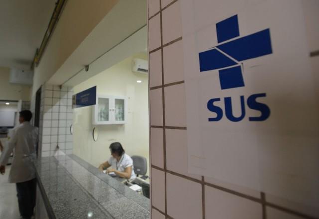 Uma sala em que são feitos atendimentos pelo SUS; Há um cartaz escrito 'SUS' na frente dela