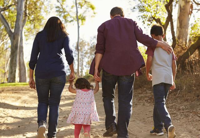 Família com homem, mulher, filho e filha caminha por trecho de areia (Divulgação/Unibes)