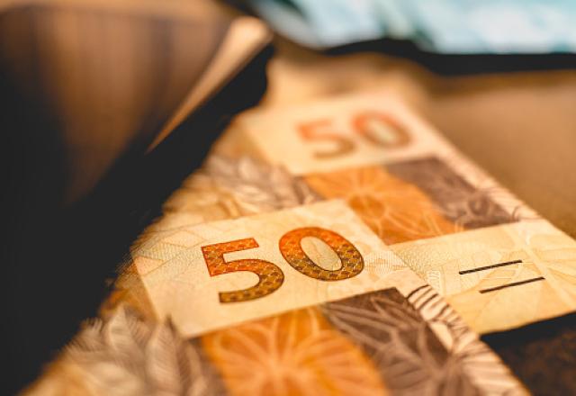 Cédulas de R$ 50,00 sobre mesa (Reprodução/Unsplash)