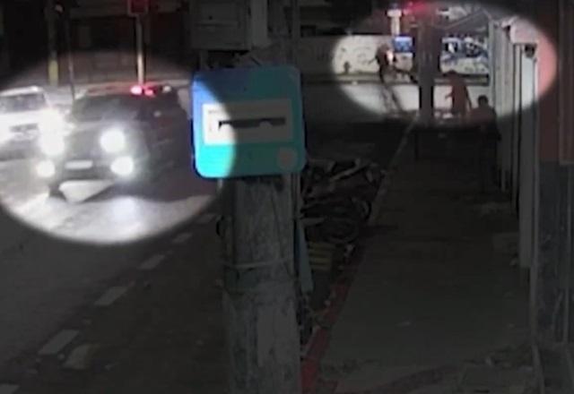 Viatura policial trafegando em rua, durante a noite