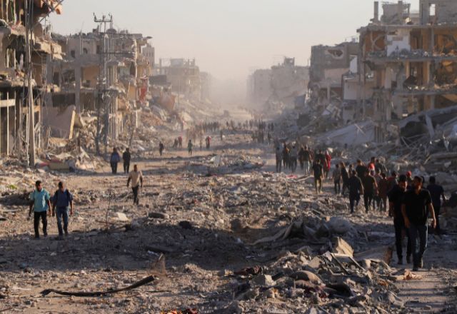 Palestinos caminham em meio a destroços na Cidade de Gaza 10/10/2025 | Foto:  REUTERS/ Ebrahim Hajjaj
