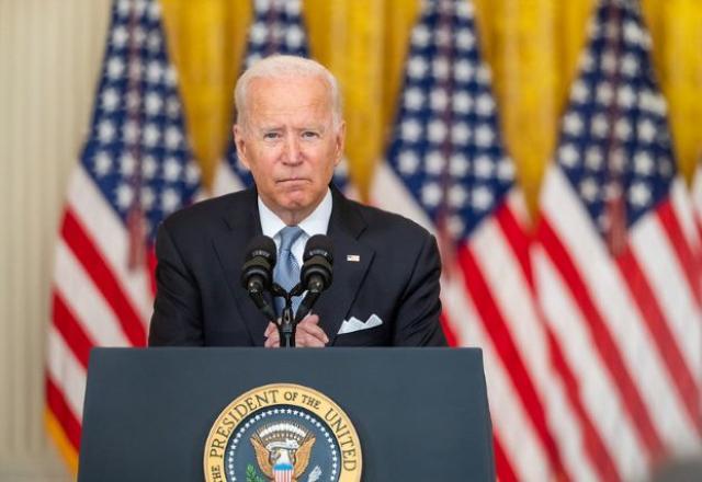 Joe  BIden fala ao microfone, à frente da bandeira dos EUA (Adam Schultz/White House)