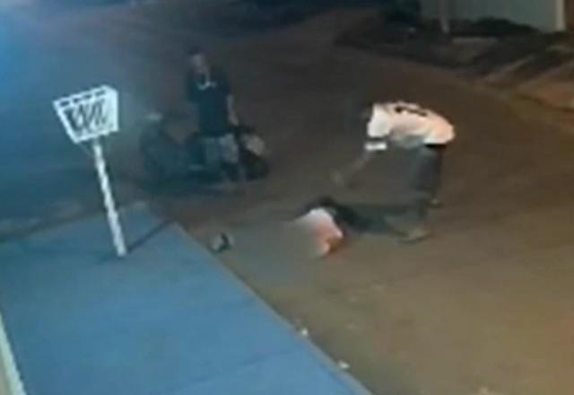 a imagem mostra dois jovens agredindo um homem em uma rua