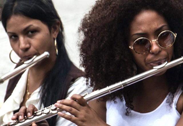 a imagem mostra duas mulheres cada uma com uma flauta na mão