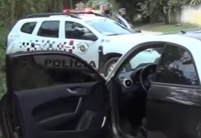 a imagem mostra o carro em que estavam os sequestradores e ao fundo o carro da polícia