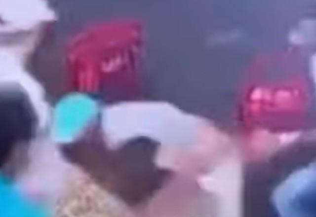 agressor de boné azul cercado por outros homens