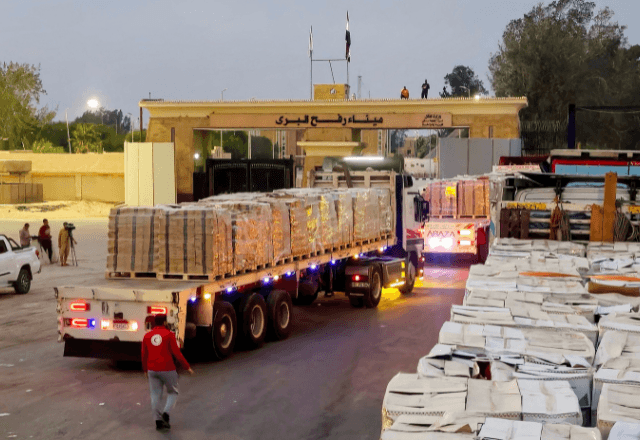 Caminhões carregando ajuda humanitária fazem fila na passagem de Rafah, na fronteira entre Egito e Faixa de Gaza | Foto: reprodução/Reuters 