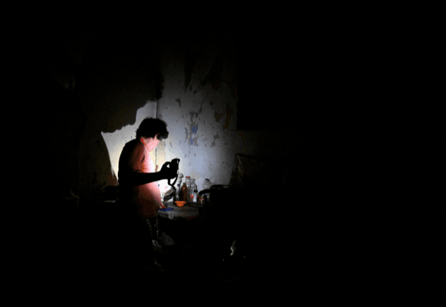Homem usa uma lanterna durante um apagão causado pelo colapso da rede elétrica nacional de Cuba, em Havana | Foto: reprodução/Reuters