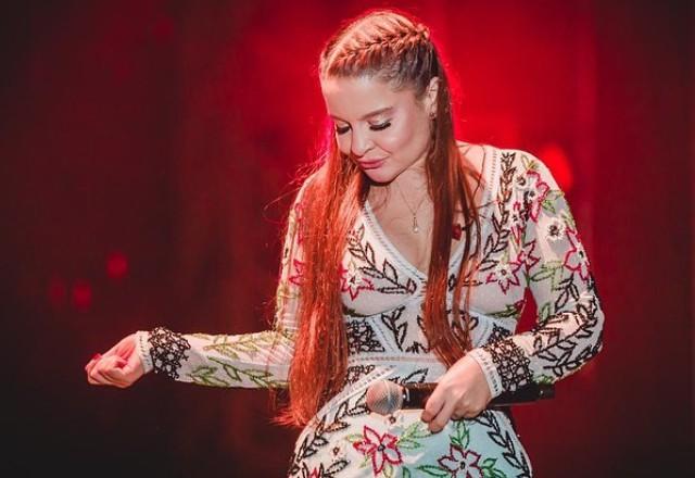 cantora maiara com microfone na mão