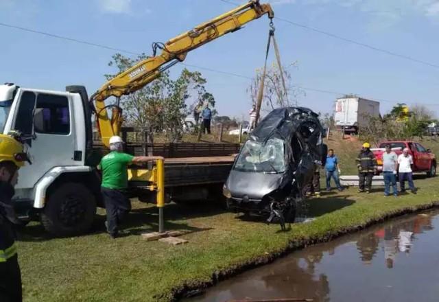 carro é retirado da água por guindaste