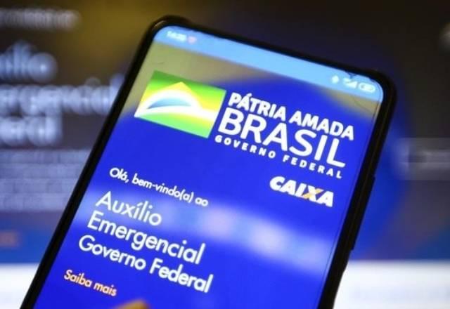 celular com aplicativo do auxilio emergencial nas mãos de um homem