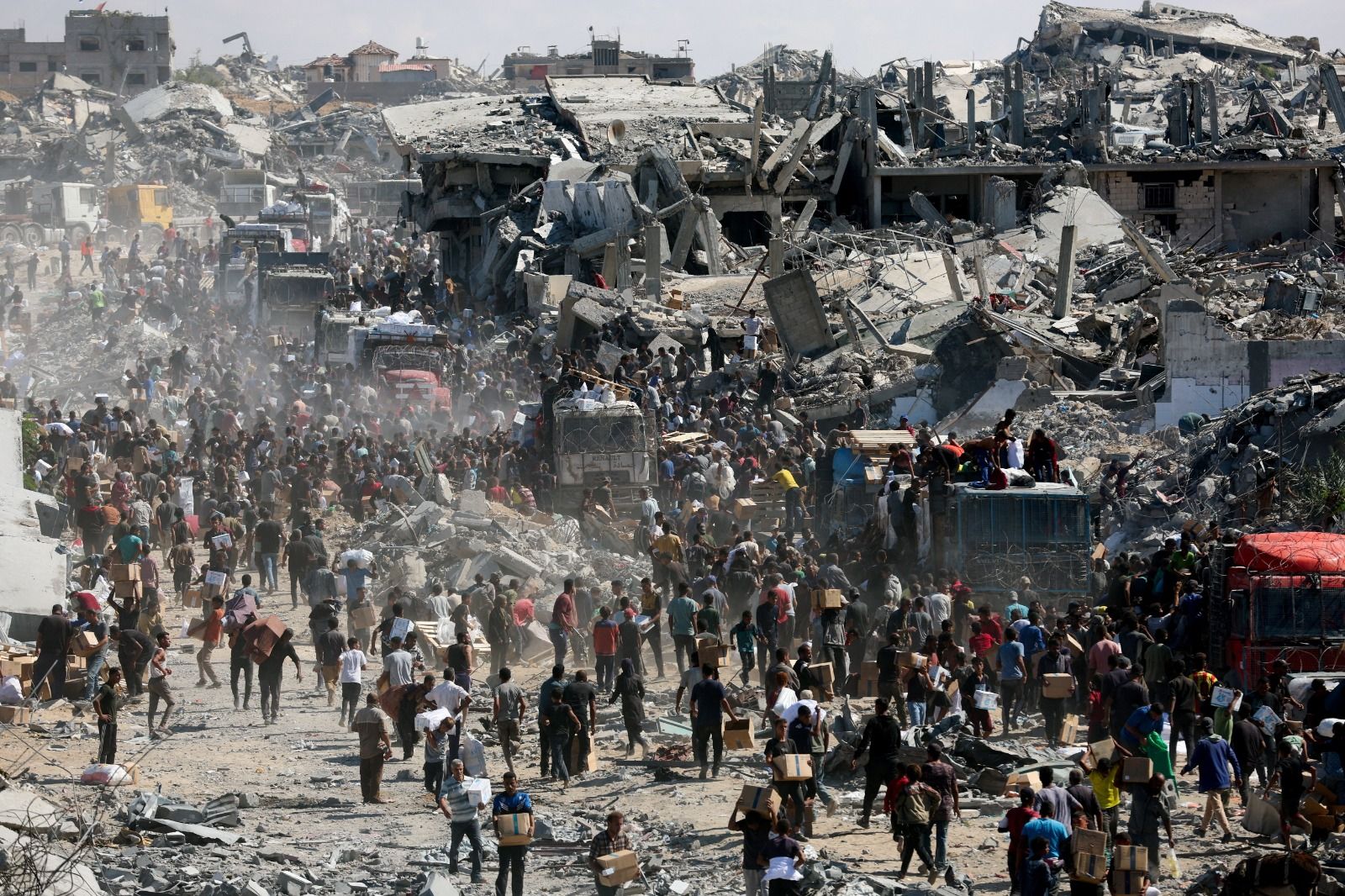 Palestinos buscam suprimentos de ajuda de caminhões que entraram em Gaza | Foto: Ramadan Abed/Reuters - 12.10.2025