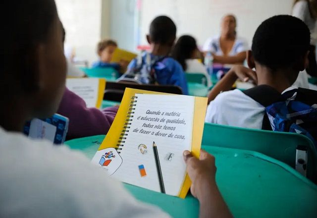 Estudante segura papel com a escrita "Quando a matéria é educação de qualidade, todos nós temos de fazer o dever de casa" (Tânia Rêgo/Agência Brasil)