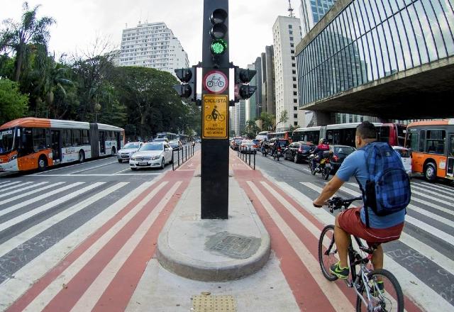 foto tirada na ciclovia central da avenida paulista. Pode-se ver o masp, ciclista e veículos