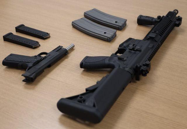 fuzil e pistola em cima de uma mesa