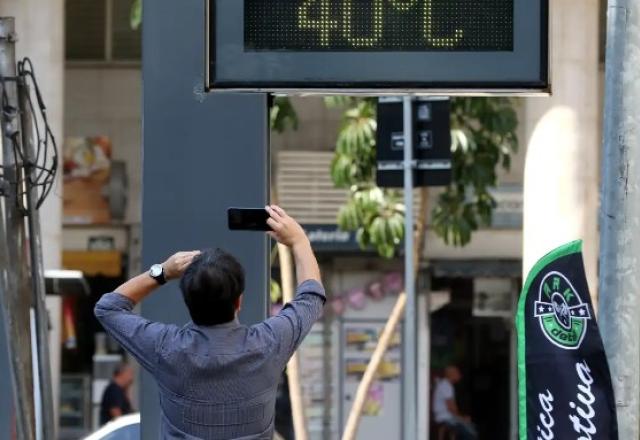 homem fotografa termometro na rua marcando 40 graus