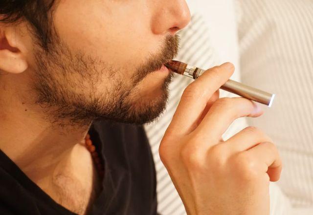 homem fumando um cigarro eletrônico, vapirizador ou vaper