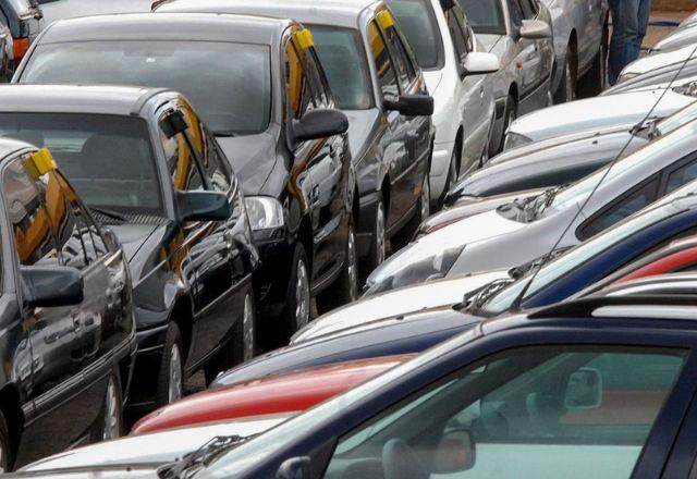 imagem mostra carros em pátio de fábrica, estacionados
