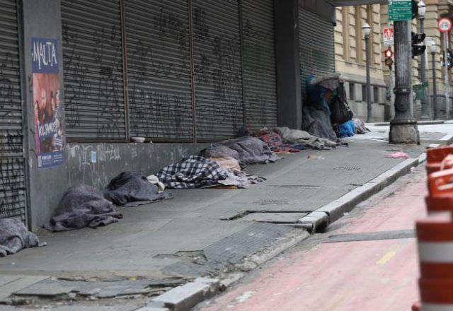 imagem mostra pessoas dormindo na rua