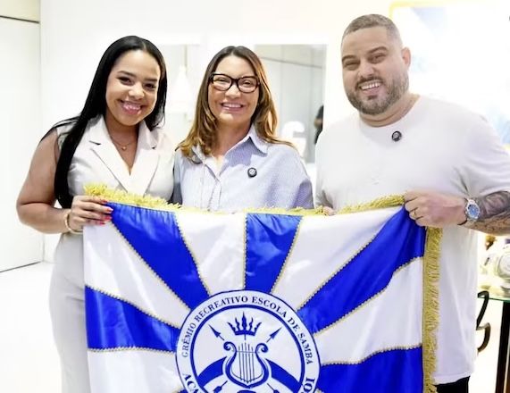 A primeira-dama Janja (ao centro) segura a bandeira da Acedêmicos de Niterói com os patronos da escola | Divulgação