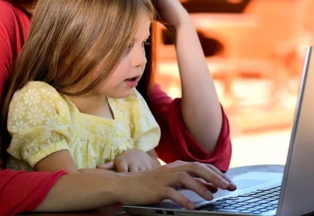mãe com criança mexendo em computador
