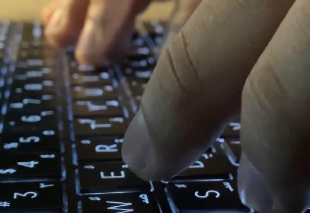 mão mexendo em teclado de computador