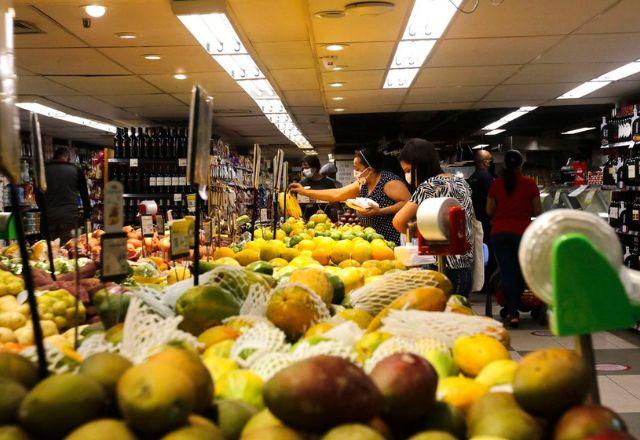 mulher escolhe fruta em supermercado