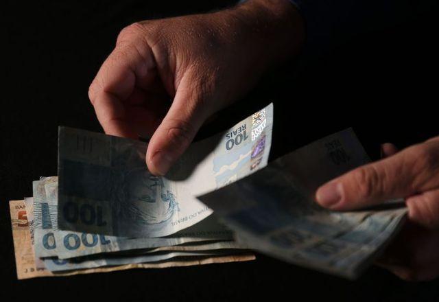 notas de 100 reais sendo contadas