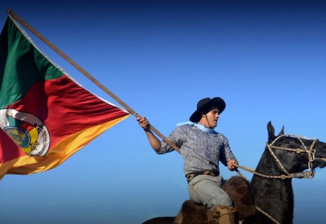 o gaúcho no lombo do cavalo crioulo com a bandeira do estado RS