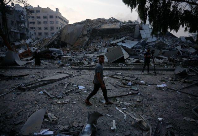 palestino anda por destroços de prédios em Gaza