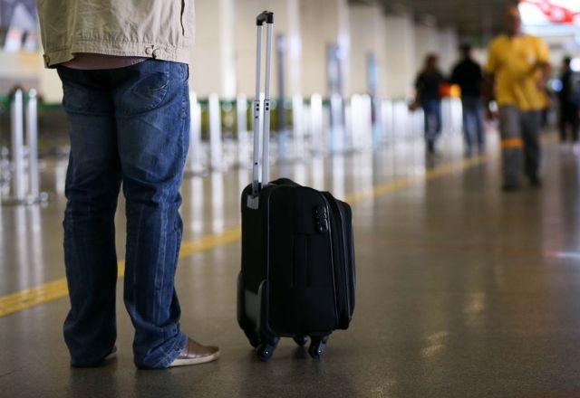 passageiro com mala em aeroporto