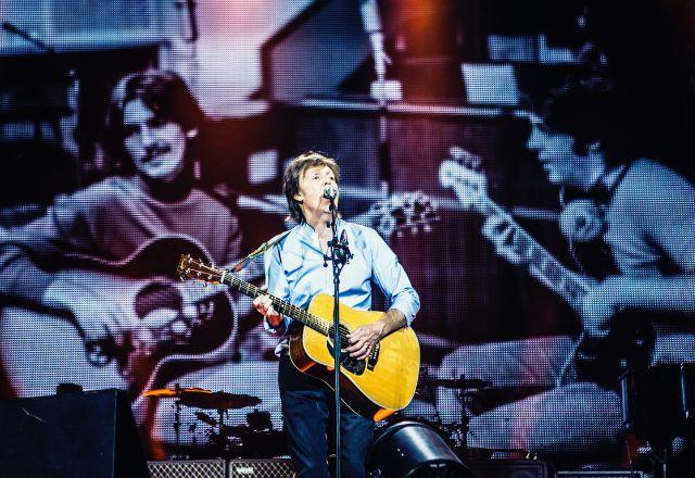 paul mccartney tocando guitarra durante show
