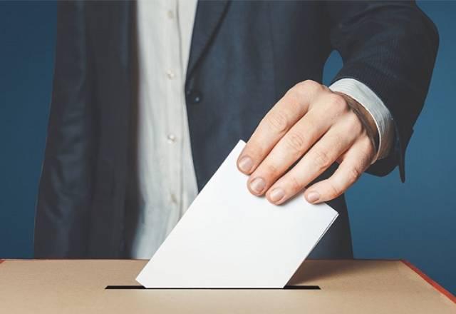 pessoa colocando voto impresso na urna