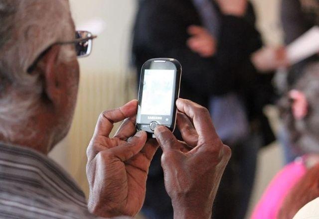pessoa idosa lendo uma informação no celular