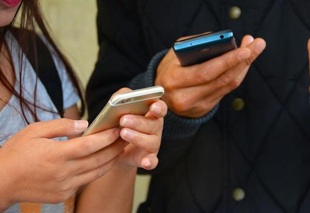 pessoas com celulares em mãos