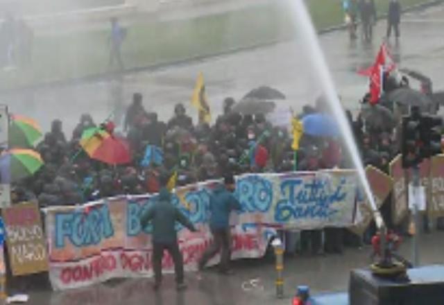 polícia usando jatos d'água contra manifestantes