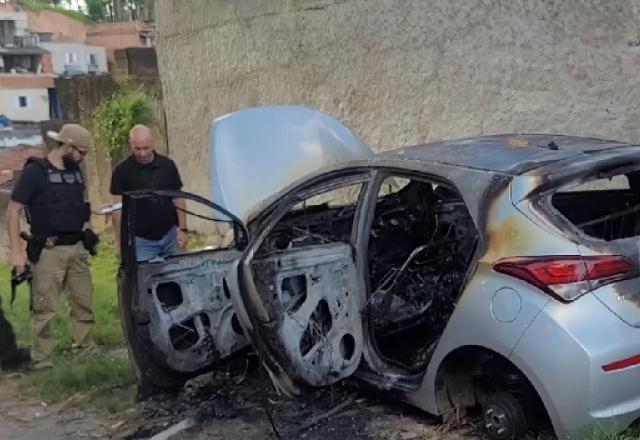 policiais vendo carro queimado