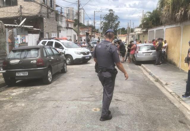 policial na rua em frente ao local do crime
