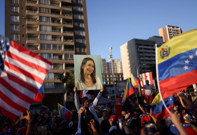Retrato de María Corina Machado entre as bandeiras dos EUA e da Venezuela em Santiago | Foto: 03/01/2026 REUTERS/Pablo Sanhueza