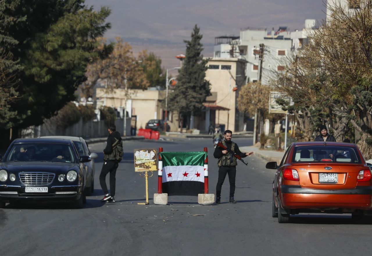 Rebeldes sírios em um posto de controle em Damasco, capital da Síria, nesta segunda (9) | Omar Sanadiki/AP