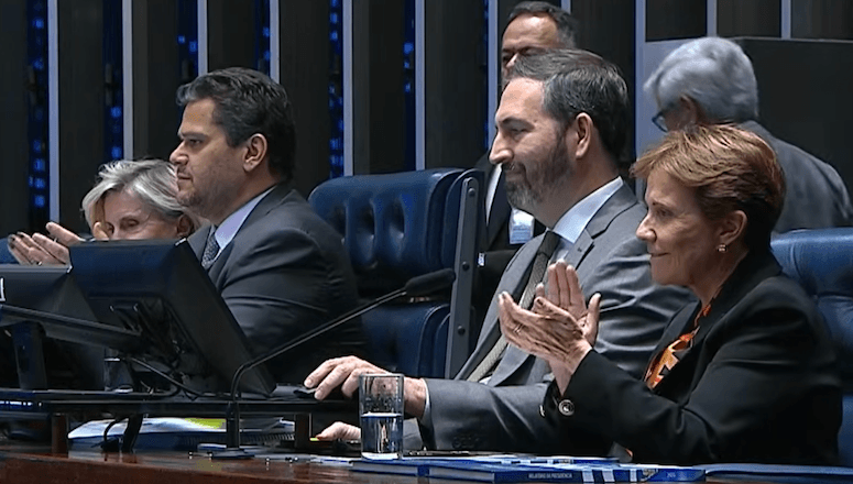 O presidente do Congresso, Davi Alcolumbre (esq.), e a senadora Tereza Cristina aplaudem a aprovação do acordo | Reprodução/YouTube