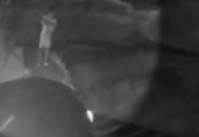 vizinho caminhando em direção ao condomínio mexendo na mochila antes de ser baleado